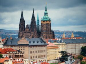 Perspective of Prague Castle, surrounded by houses under the blue sky