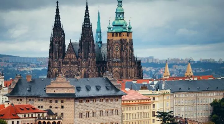 Perspective of Prague Castle, surrounded by houses under the blue sky